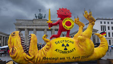 Prie&scaron;ais Brandenburgo vartus aktyvistai simboli&scaron;kai užmu&scaron;ė dirbtinį dinozaurą.