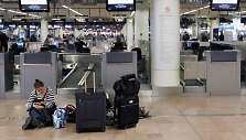 Moteris sėdi ant žemės Zaventem oro uoste