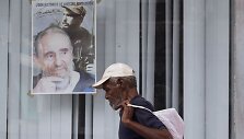 Kubietis eina pro Fidelio Castro, &scaron;venčiančio 87-eptintąjį gimtadienį, plakatą.