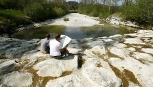 Vyrai sėdi i&scaron;džiuvusioje Tioso upės vagoje