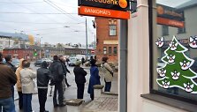 Žmonės stoja į ilgą eilę Rygoje, kad atsiimtų savo pinigus i&scaron; &bdquo;Swedbank&ldquo; bankomato.