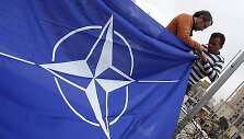 Darbininkai Tiranoje, Albanijos sostinėje, rengiasi i&scaron;kelti NATO vėliavą.