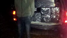 Kontrabandines cigaretes vežęs vyras prie automobilio