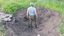 Ukrainos karys stovi haubicos smūgio paliktame krateryje.