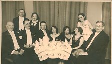 Pobūvio svečiai prie vai&scaron;ių stalo Latvijos pasiuntinybėje. I&scaron; kairės: trečias sėdi režisierius Andrius Oleka-Žilinskas, už jo stovi aktorė Antanina Vainiūnaitė. Antra i&scaron; de&scaron;inės stovi aktorė E. Žalinkevičaitė-Petrauskienė, sėdi operos solistė  Vincė Jonu&scaron;kaitė-Zaunienė, &scaron;alia jos visuomenininkė Jadv