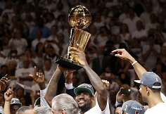 LeBronas Jamesas su NBA trofėjumi rankose