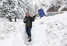 Moteris kasa sniegą &scaron;alia savo namų
