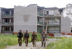 Ukrainos kariai patruliuoja prie sugriautų namų Širokine, Ukrainoje