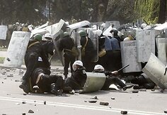Policininkai bėga nuo įsiutusios minios.