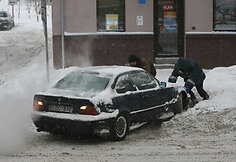 Kauniečiai stumia mašiną.