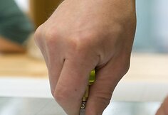 Stiklininkas demonstruoja, kaip pjaunamas stiklas. 