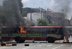 Protesto akcijos dalyviai padeginėja autobusus.