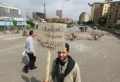 Protestuotojas laiko plakatą, ant kurio užra&scaron;yta: &bdquo;Kodėl kariuomenė mus puola? Gal mes esame Libijoje?&ldquo;