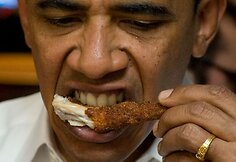 Obama Barackas skaniai valgo gruzdintos varlės  koją.