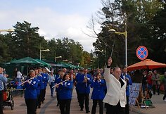 Gatve marširavo ir orkestras.