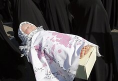 Moteris laiko lėlę, simbolizuojančią nužudytą palestiniečių vaiką.
