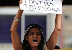 Palestiniečių bendruomenės narė Venesueloje protestuoja prie Izraelio ambasados. Ant plakato parašyta: „etninis valymas prieš Palestiną“