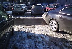 Per dvi vietas perpildytoje aikštelėje pastatyta mašina.