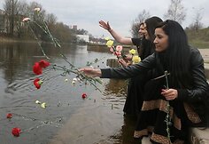 Romų merginos plukdo gėles upe