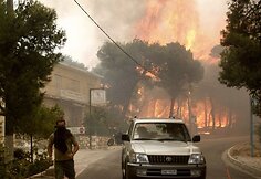 Gaisrui pasiekus Atėnus ugniagesiai kovoja su liepsnomis, o žmonės evakuojami iš priemiesčių.
