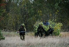 Prezidentė sėdo prie karinio šarvuočio vairo ir išbandė net kulkosvaidį