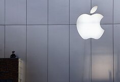 Policininkas iš balkono stebi prie „Apple“ parduotuvės susirinkusius žmones.