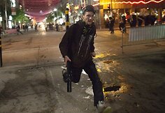 Nuo policijos bėgantis protestuotojas