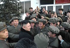 Kim Jong-Unas su &scaron;alies mokslininkais džiaugiasi sėkmingu raketos paleidimu.