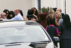 Guodžiami į laidotuves atvykę Reevos Steenkamp tėvai Barry (kairėje) June Steenkamp (de&scaron;inėje, &scaron;viesiai pilku &scaron;varku)