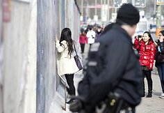 Merginos fotografuojasi &scaron;alia Berlyno sienos