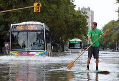 Vyras ant banglentės plaukia per sankryžą.