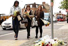 Merginos ne&scaron;a gėles į vietą, kur buvo nužudytas Lee Rigby