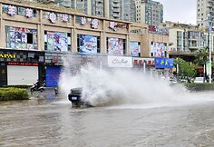 Automobilis važiuoja apsemta gatve.