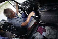 Oscaras Almagueras sėdi savo automobilyje „Volkswagen Beetle“