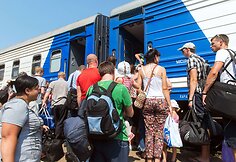 I&scaron; Rytų Ukrainos i&scaron;važiuojantys žmonės lipa į traukinį.