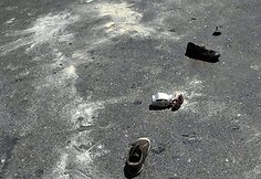 Ant gatvės guli protestuotojų batai ir vėliavos.