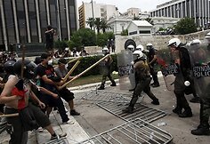 Šalmais ir pagaliais apsiginklavę protestuotojai susirėmė su riaušių policija.