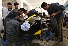 Studentai prie sukonstruoto automobilio 