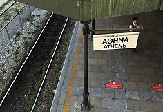 Apsaugos darbuotojas vaikšto ant tuščios platformos pagrindinėje Atėnuose traukinių stotyje.