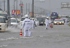 Tojokavoje automobiliai važiuoja apsemtu keliu.