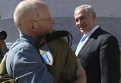 Izraelio ministras pirmininkas Benjaminas Netanyahu (de&scaron;inėje) žiūri į apsikabinusius Giladą Shalitą ir jo tėvą.