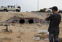 Vyras fotografuoja vietą, kurioje buvo rastas Muamaras Kadhafi