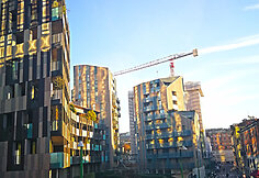Daugiaauk&scaron;čiai &scaron;alia Piazza gae aulenti esant saulėlydžiui