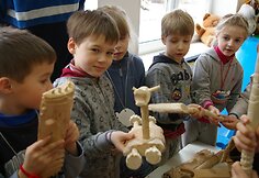 Vaikai džiaugiasi mediniais dirbiniais