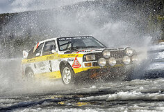  1984 m. legendinis &scaron;vedų lenktynininkas Stigas Blomquistas i&scaron;kovojo pasaulio ralio čempiono titulą ir kartu užtikrino &bdquo;Audi&ldquo; pergalę tarp automobilių gamintojų.
