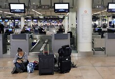 Moteris sėdi ant žemės Zaventem oro uoste