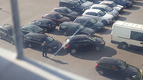 Merginos vargai bandant išvažiuoti iš automobilių stovėjimo aikštelės