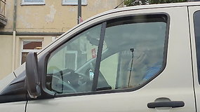Vaizdas pro nežymėto policijos automobilio langą: vairuotojai nepaiso draudimo naudotis telefonu vairuojant