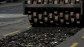 Brazilų kariai asfalto volu sunaikino tūkstančius ginklų
