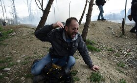 Makedonijos policija a&scaron;arinėmis dujomis vaikė migrantus nuo sienos su Graikija